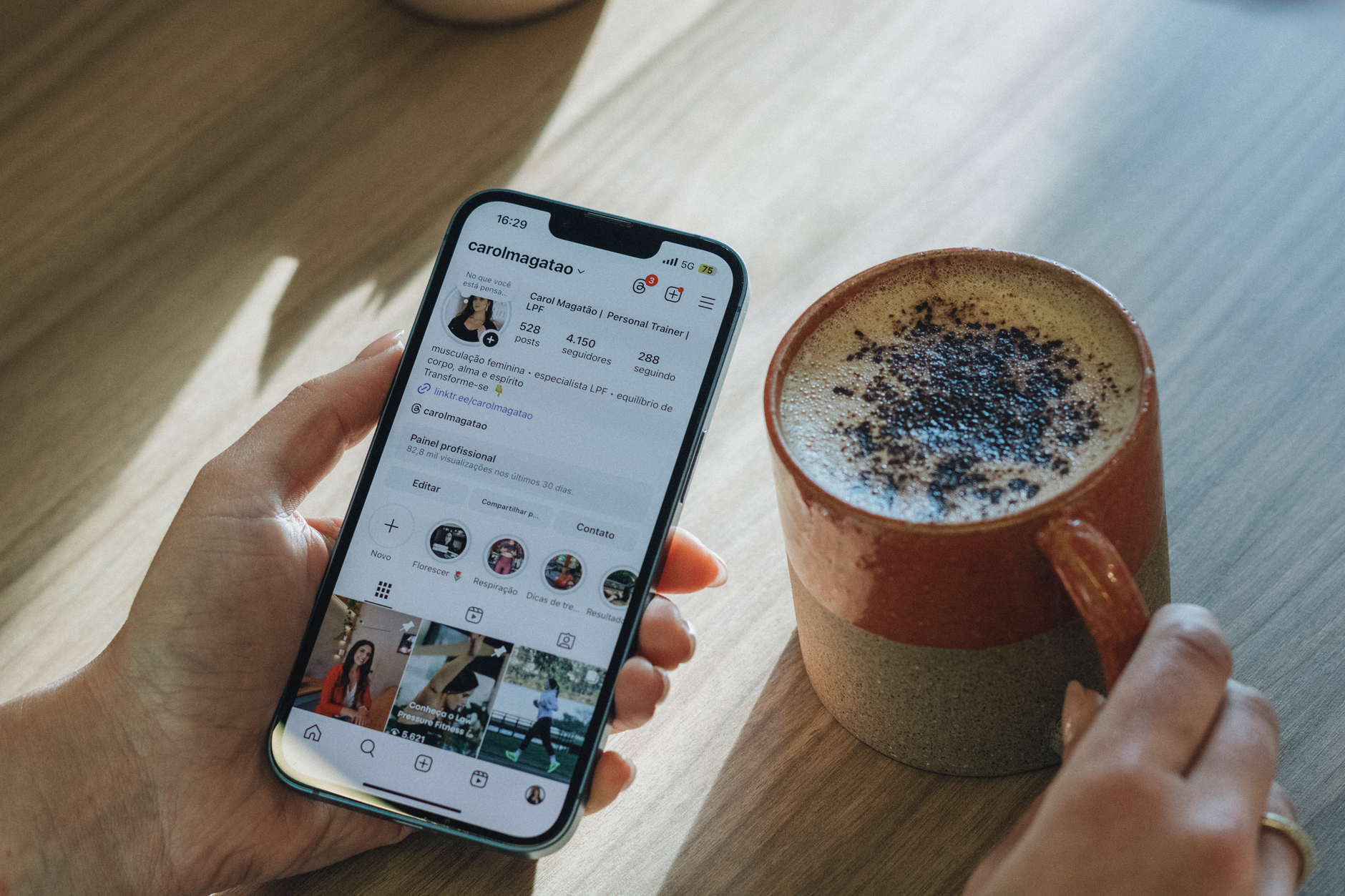 a hand holding a phone with a social media feed open